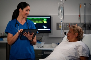 patient being consulted in a hospital by medical staff using a tablet computer